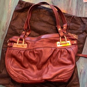 Beautiful red-brown leather bag with 3 interior pockets and gold hardware